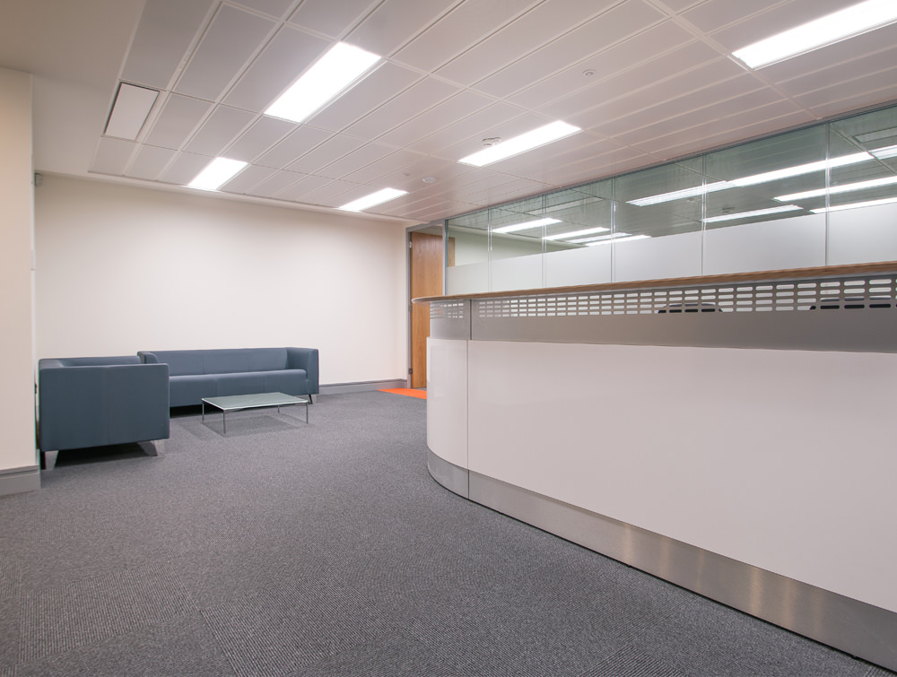 Apex Office Layout White Reception Desk with Grey Sofas and Glass Table